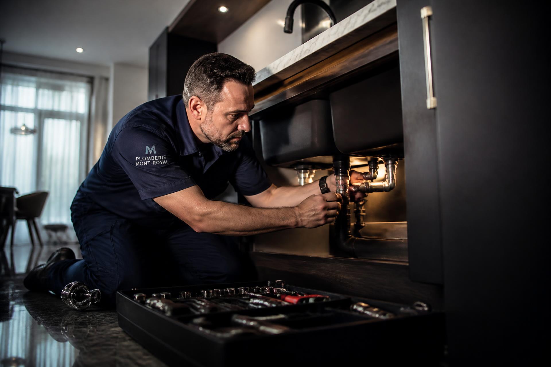 Plombier professionnel travaillant dans une résidence moderne à Montréal